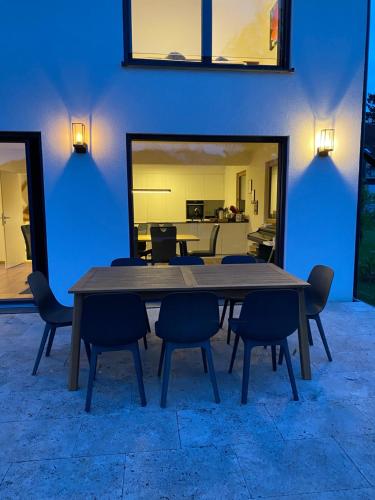 mesa de comedor con sillas y pared azul en Luxus-Anwesen mit Charme, en Koblach