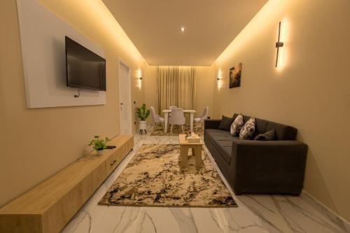 a living room with a couch and a tv at Golden House - جولدن هاوس التجمع الخامس in Cairo