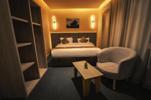 a hotel room with a bed and a chair and a table at Golden House - جولدن هاوس التجمع الخامس in Cairo