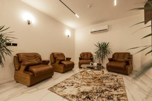a living room with leather chairs and a table at Golden House - جولدن هاوس التجمع الخامس in Cairo