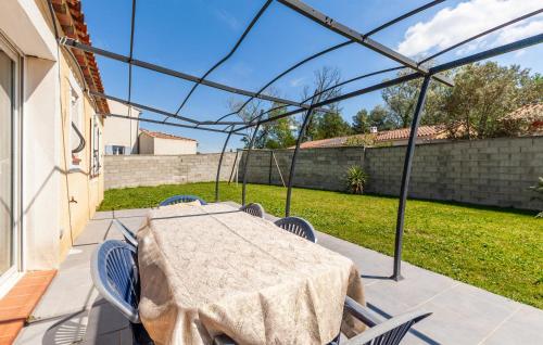 un patio avec une table et des chaises et une clôture dans l'établissement 3 Bedroom Nice Home In Plan-D'orgon, à Plan-dʼOrgon