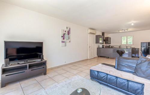 un salon avec un canapé bleu et une télévision dans l'établissement 3 Bedroom Nice Home In Plan-D'orgon, à Plan-dʼOrgon