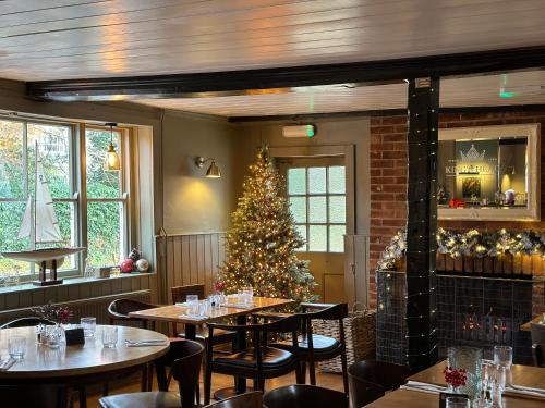 a christmas tree in a restaurant with tables and chairs at Kings Head Coltishall in Norwich