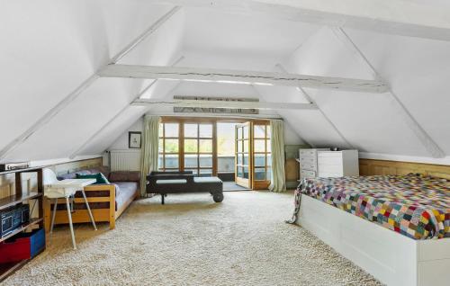 sypialnia na poddaszu z łóżkiem i biurkiem w obiekcie 3 Bedroom Lovely Home In Svendborg w mieście Svendborg