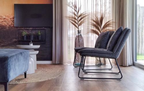 a living room with two chairs and a tv at Awesome Home In Voorthuizen With Wifi in Voorthuizen