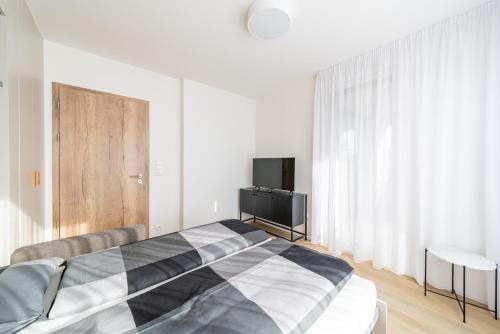 a bedroom with a black and white bed and a television at Residence Mozaika in Prague