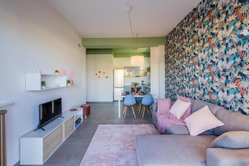 ein Wohnzimmer mit einem Sofa und einem TV in der Unterkunft Chez Monique in Oleggio Castello