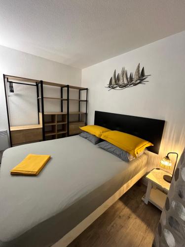 a bedroom with a large bed with yellow pillows at Pampelonne Appartment in La Croix-Valmer