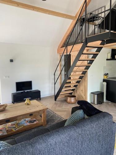 a living room with a blue couch and a staircase at Op den Distelberg in Helvoirt