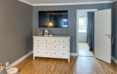 a room with a white dresser with a lamp on it at Beautiful Home In Örebro With Kitchen in Örebro