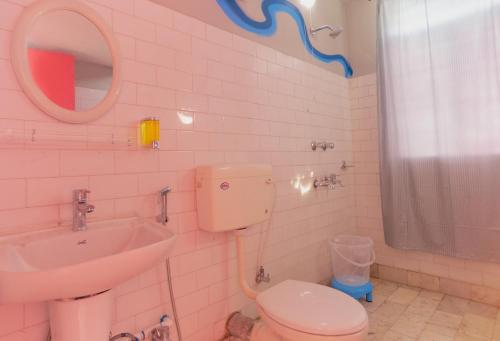 a bathroom with a toilet and a sink and a mirror at malini homes Unit - 1 in Guwahati