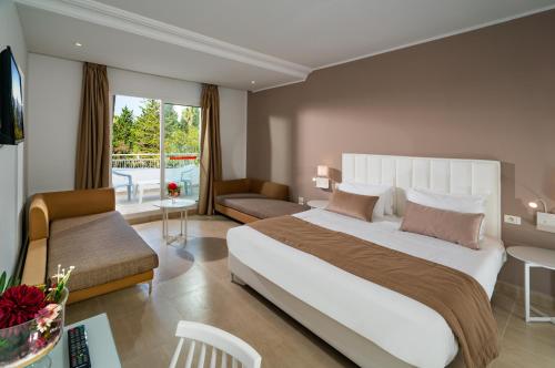 a bedroom with a large bed and a living room at Golden Tulip Président Hammamet in Hammamet