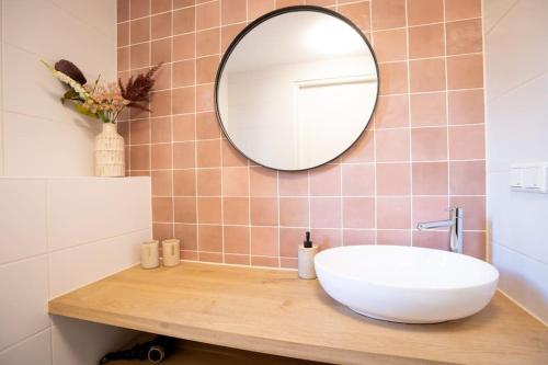 La salle de bains est pourvue d'un lavabo blanc et d'un miroir. dans l'établissement Lagom I Tiny House, à Epe