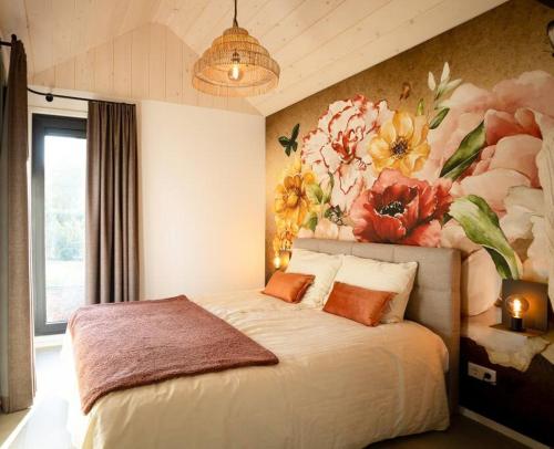 a bedroom with a bed with a flower painting on the wall at Lagom I Tiny House in Epe