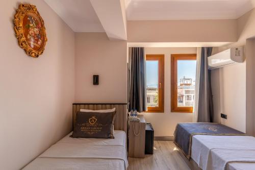 a hotel room with two beds and a window at Akkan Hotel in Bodrum City
