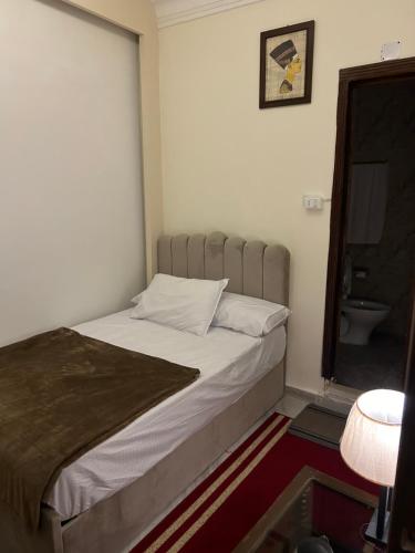 a bed in a small room with a toilet at Matto Pyramids Inn in Cairo