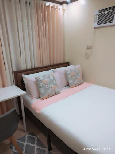 a bedroom with a bed with pillows and a window at Casita de Reina Staycation House - A cozy 1-Bedroom condo-style house in Daraga