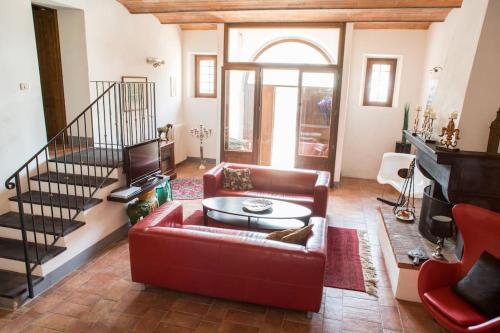 een woonkamer met een rode bank en een tafel bij Oasi nel cuore del Chianti in San Sano