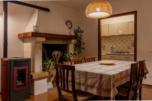 a dining room with a table and a fireplace at Sunset House - Casa al Tramonto in Selva di Progno