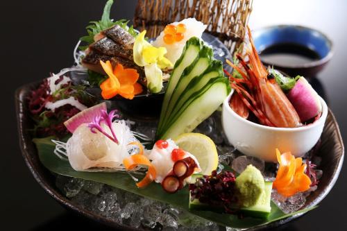 a plate of food with sushi and vegetables on it at Taikyourou in Miyazu