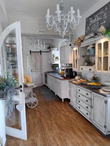 a kitchen with white cabinets and a chandelier at Grotta dei Puntali B&B in Carini