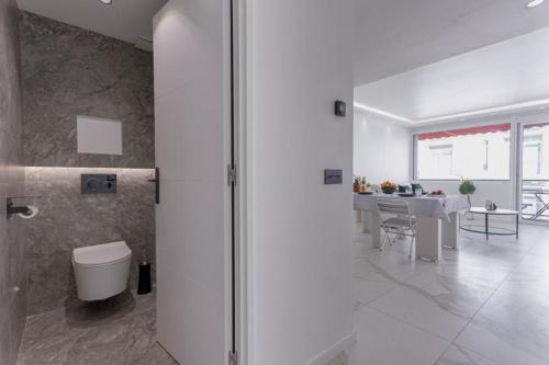 une salle de bains blanche avec toilettes et une salle à manger. dans l'établissement Lunique Maubourg - Next Hôtel Martinez - terrasse, à Cannes