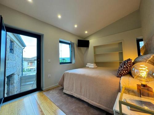 - une chambre avec un grand lit et une grande fenêtre dans l'établissement GuestReady - An Amazing Retreat in Várzea do Douro, à Marco de Canavezes