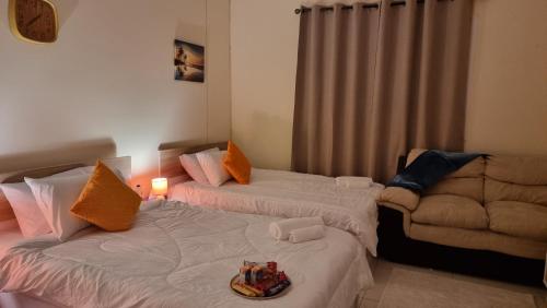 a bedroom with two beds and a couch at Deluxe Rooms in Al Mamzar SHJ Shared bathroom in Sharjah
