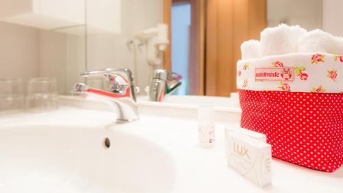 a bathroom sink with a red and white towel holder at Gasthof Menüwirt in Sankt Kanzian