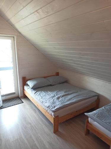 a bedroom with a bed in a attic at Anetta Domki Mielno in Mielno