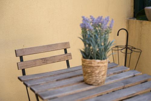 un vase de fleurs violettes assis sur une table en bois dans l'établissement GuestReady - São Brás Mezzanine, à Porto