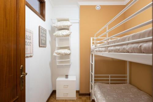 Cette petite chambre comprend des lits superposés et une porte. dans l'établissement GuestReady - Bright and Modern 2BR Flat in Vila Nova de Gaia, à Porto