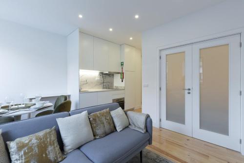 a living room with a couch and a kitchen at GuestReady - Cosy and Modern Apartment 4mins from Metro in Porto