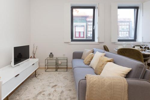 a living room with a blue couch and a tv at GuestReady - Cosy and Modern Apartment 4mins from Metro in Porto