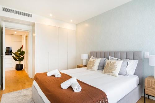 a bedroom with a large white bed with white pillows at GuestReady - Asaf's Magnolias Retreat in Vila Nova de Gaia