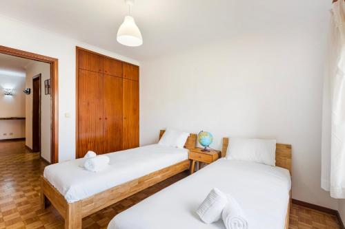 Habitación con 2 camas individuales y paredes blancas. en GuestReady - Exclusive Retreat in Lavra, en Lavra