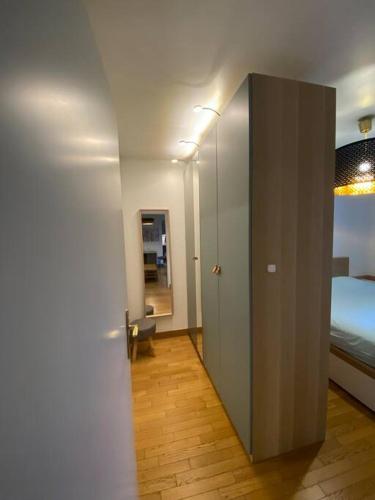 un couloir avec une porte menant à une chambre dans l'établissement Appartement avec terrasse - Paris Montrouge, à Montrouge