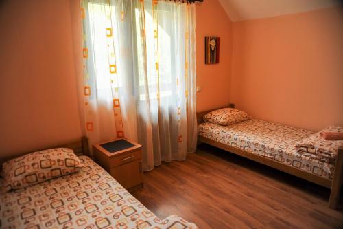 1 dormitorio con 2 camas y una ventana con cortinas en LOVCEN4ME en Cetinje