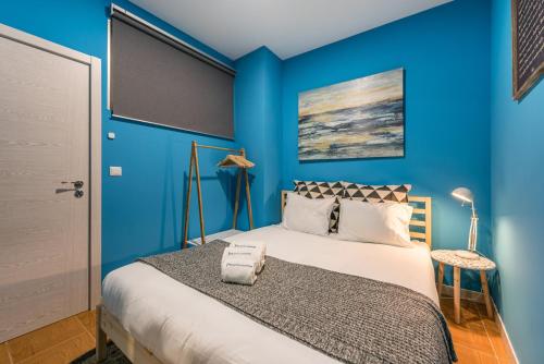 a blue bedroom with a bed with a blue wall at GuestReady - Miragaia Historical Sight in Porto