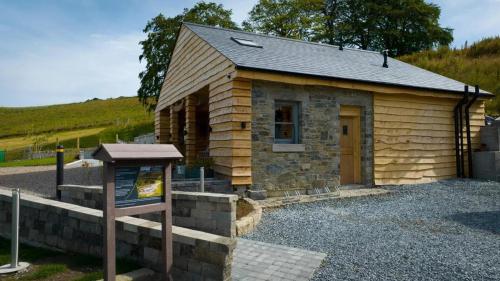 a small building with a sign in front of it at Forestview Cabin No 1 - cosy cabin stay in Ballynahinch