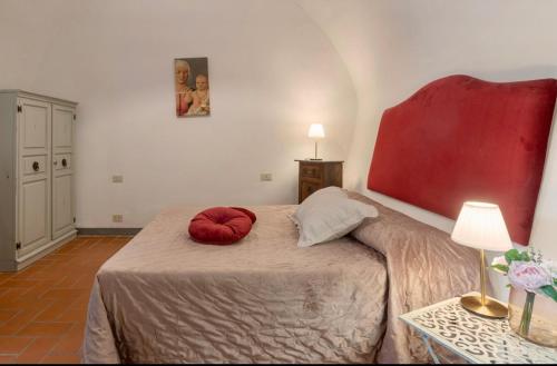 a bed with two red pillows on it in a room at Le Fonti di San Gimignano in San Gimignano