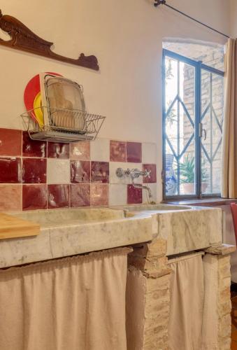 a kitchen with a stone counter and a window at Le Fonti di San Gimignano in San Gimignano