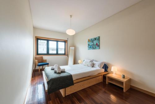 ein Schlafzimmer mit einem Bett, einem Stuhl und einem Fenster in der Unterkunft GuestReady - Even Flow Flat in Porto