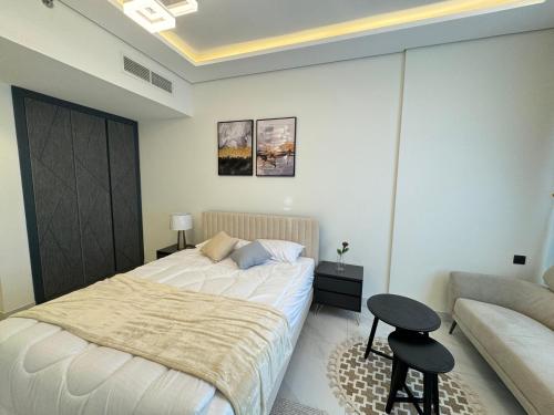 a bedroom with a bed and a couch at Furnished studio استديو مفروش studio city in Dubai