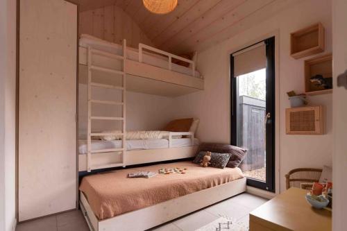 1 dormitorio con 2 literas y mesa en WØUD Tiny House en Epe