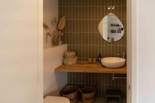 a bathroom with a sink and a mirror at WØUD Tiny House in Epe