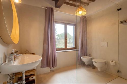 a bathroom with a sink and a toilet and a window at Le Fonti di San Gimignano in San Gimignano