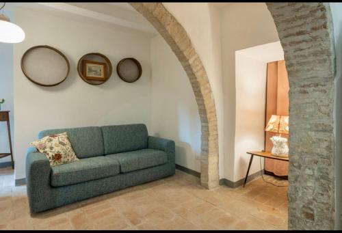 a living room with a green couch and a table at Le Fonti di San Gimignano in San Gimignano