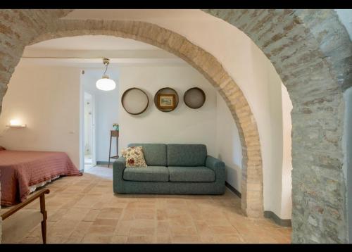 a living room with a green couch and an archway at Le Fonti di San Gimignano in San Gimignano