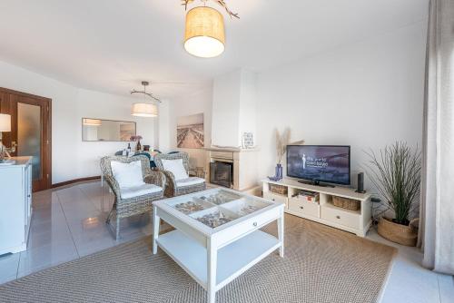 a living room with a couch and a tv at GuestReady - Madalena Beach Pool & Tennis in Vila Nova de Gaia